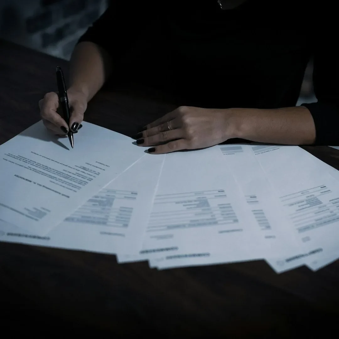 Person signing solar installation paperwork, representing MCS submission and compliance documentation.