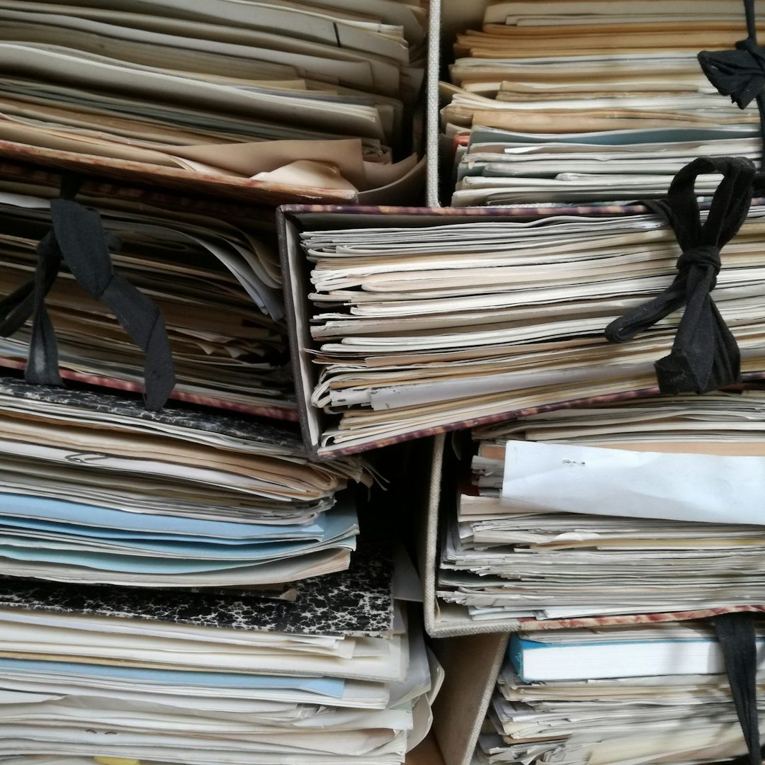 A file cabinet filled with old MCS handover paperwork stored in various folders. 